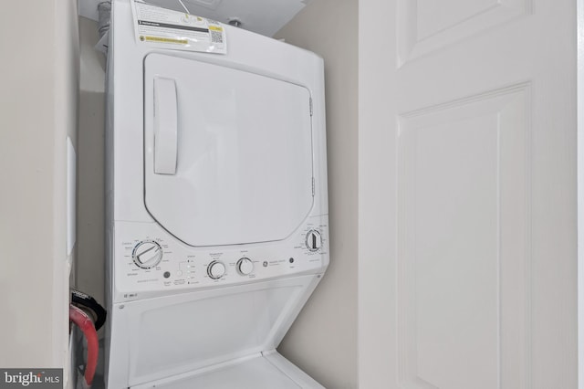 washroom featuring stacked washer / drying machine and laundry area
