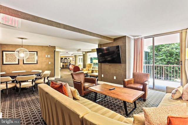 living room featuring baseboards, beamed ceiling, and a wall of windows
