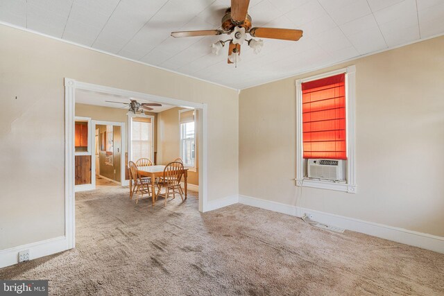 carpeted empty room featuring cooling unit, ceiling fan, and baseboards