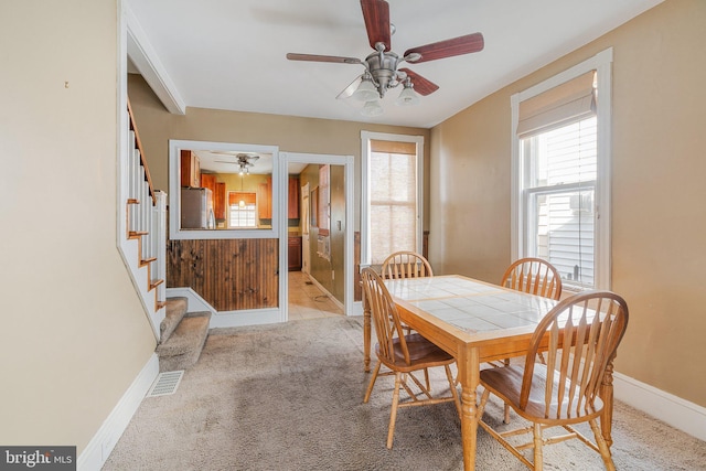dining room featuring a wealth of natural light, ceiling fan, stairs, and baseboards