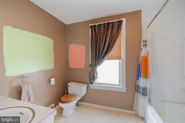 bathroom with baseboards, toilet, and vanity
