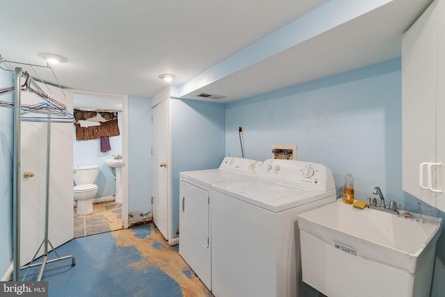 clothes washing area with visible vents, washing machine and clothes dryer, laundry area, and a sink