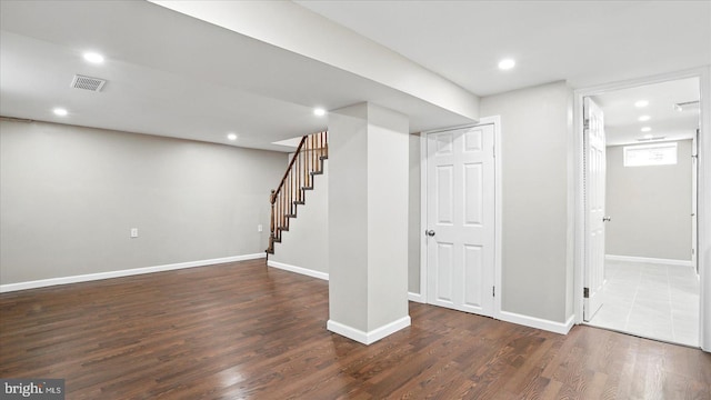 5427 Gradin Ave, Gwynn Oak, MD 21207 - below grade area with dark wood-style flooring, visible vents, baseboards, and stairs