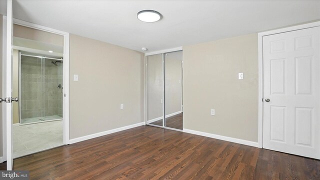 5427 Gradin Ave, Gwynn Oak, MD 21207 - unfurnished bedroom with a closet, baseboards, connected bathroom, and wood finished floors