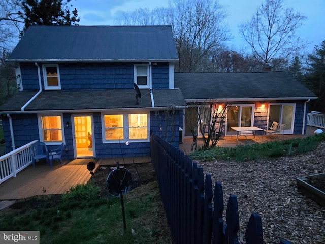 back of house featuring a deck and a shingled roof