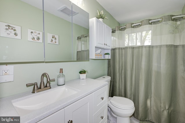 full bathroom featuring vanity, curtained shower, visible vents, and toilet