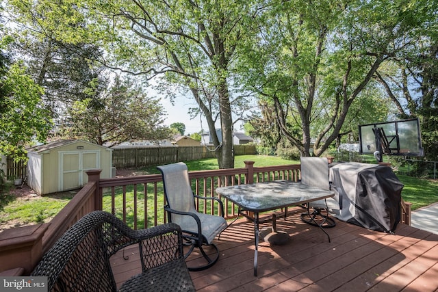 wooden deck with area for grilling, a shed, a fenced backyard, an outdoor structure, and a yard