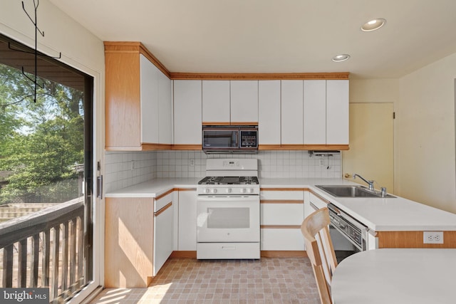 2418 Berkshire Ln, Dover, PA 17315 - kitchen with black microwave, white gas range, a sink, light countertops, and a peninsula