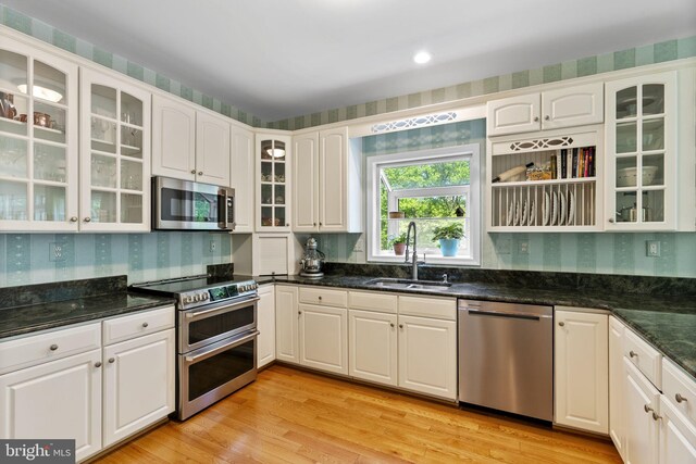117 Graystone Farm Rd, White Hall, MD 21161 - kitchen featuring appliances with stainless steel finishes, a sink, white cabinetry, light wood-style floors, and glass insert cabinets