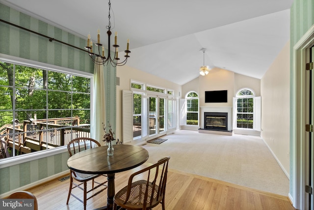 117 Graystone Farm Rd, White Hall, MD 21161 - dining space with wood-type flooring, a chandelier, a glass covered fireplace, vaulted ceiling, and baseboards
