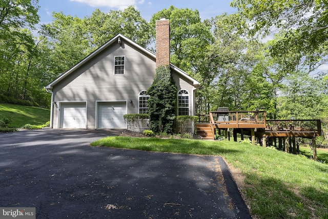 117 Graystone Farm Rd, White Hall, MD 21161 - view of home's exterior featuring driveway, a wooden deck, a chimney, a garage, and a lawn