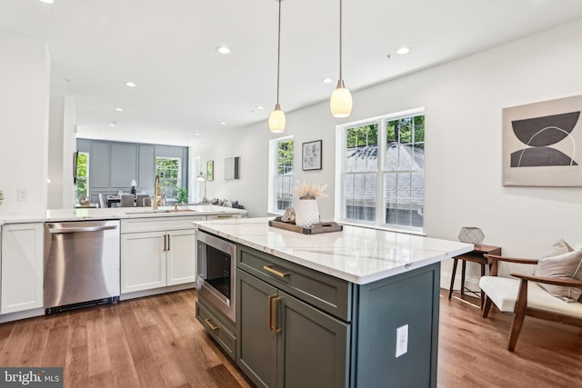 322 56th St NE, Washington, DC 20019 - kitchen with white cabinets, appliances with stainless steel finishes, light stone counters, and wood finished floors