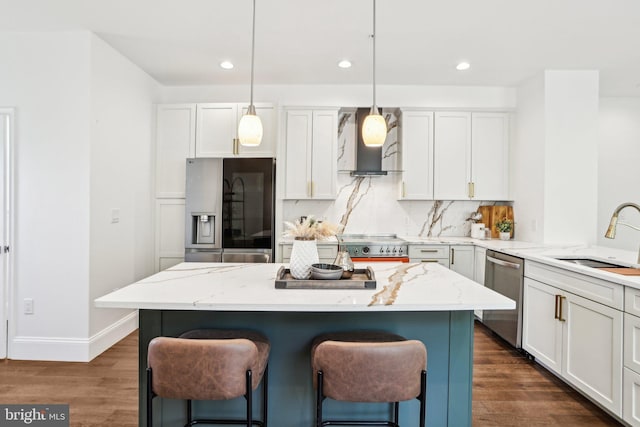 322 56th St NE, Washington, DC 20019 - kitchen featuring a kitchen bar, a sink, wall chimney exhaust hood, appliances with stainless steel finishes, and a kitchen island