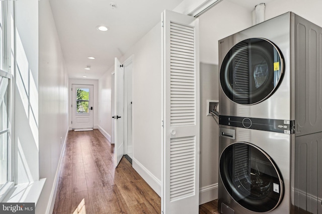 322 56th St NE, Washington, DC 20019 - laundry room with laundry area, stacked washer / dryer, wood finished floors, and baseboards