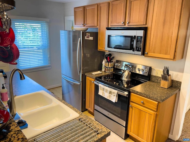 518 Meade Ave, Charlottesville, VA 22902 - kitchen with a sink, appliances with stainless steel finishes, brown cabinets, baseboards, and dark countertops