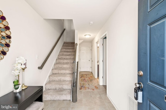 foyer entrance featuring stairway, visible vents, and light tile patterned flooring