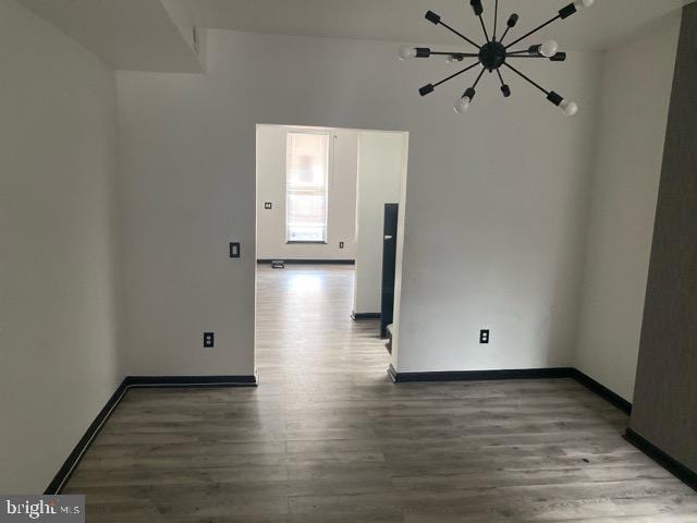 2739 Riggs Ave, Baltimore, MD 21216 - unfurnished room featuring a notable chandelier, wood finished floors, and baseboards