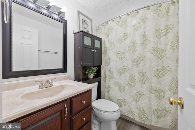 bathroom featuring a textured ceiling, toilet, wood finished floors, curtained shower, and vanity