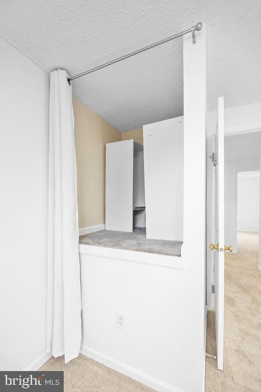 carpeted empty room with a textured ceiling