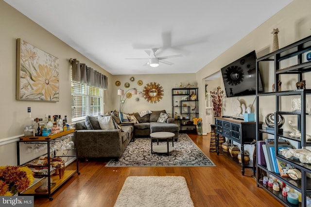 living area with wood finished floors and ceiling fan