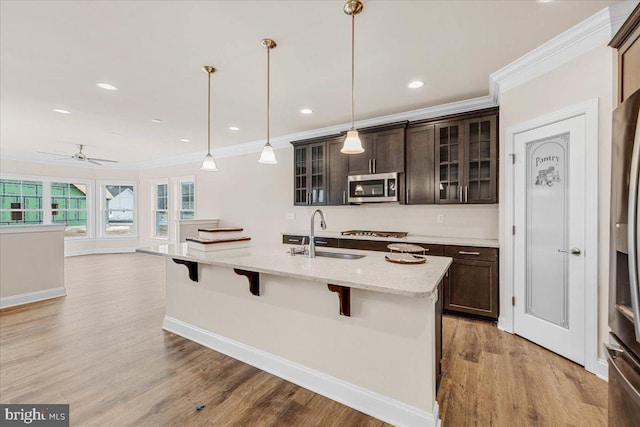 12524 Salisbury Rd, Ocean City, MD 21842 - kitchen with a sink, stainless steel microwave, crown molding, gas stovetop, and a breakfast bar area