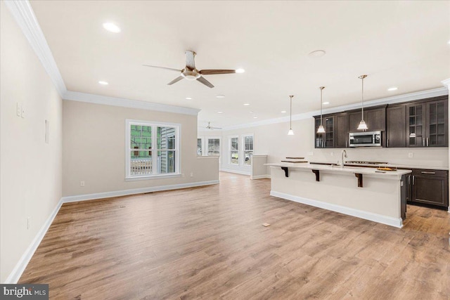 12524 Salisbury Rd, Ocean City, MD 21842 - kitchen with a ceiling fan, ornamental molding, stainless steel microwave, and a breakfast bar area