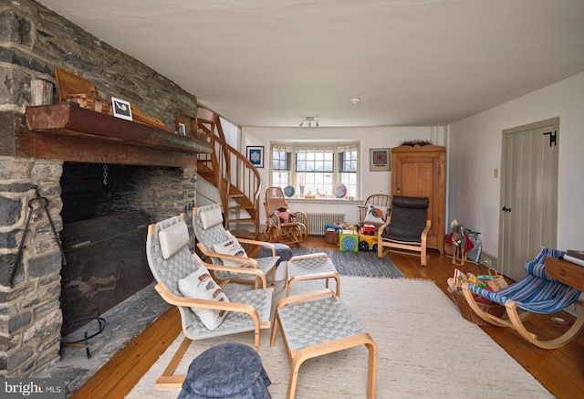 3837 Curly Hill Rd, Doylestown, PA 18902 - living area with wood-type flooring, stairs, radiator heating unit, and a fireplace