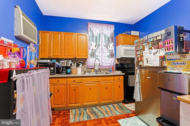 3903 N Marshall St, Philadelphia, PA 19140 - kitchen with black / electric stove, white microwave, light countertops, freestanding refrigerator, and a sink