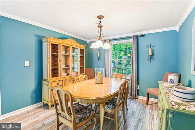 dining room featuring baseboards, ornamental molding, and light wood-style flooring