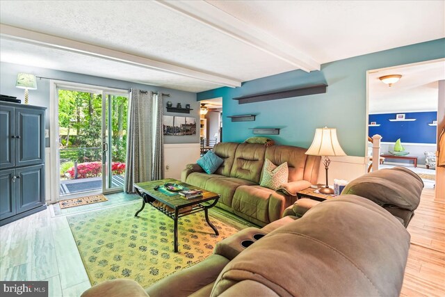 living room with beam ceiling and wood finished floors