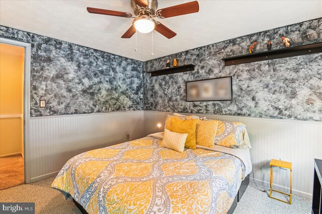 bedroom with carpet flooring, baseboards, and wainscoting