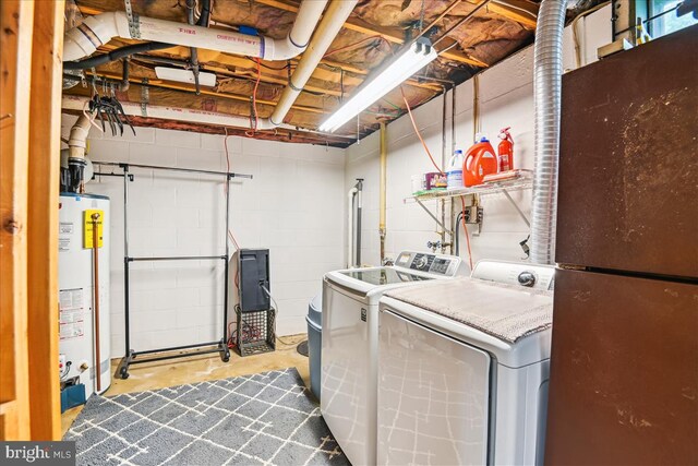 laundry area with concrete block wall, gas water heater, laundry area, and washer and clothes dryer