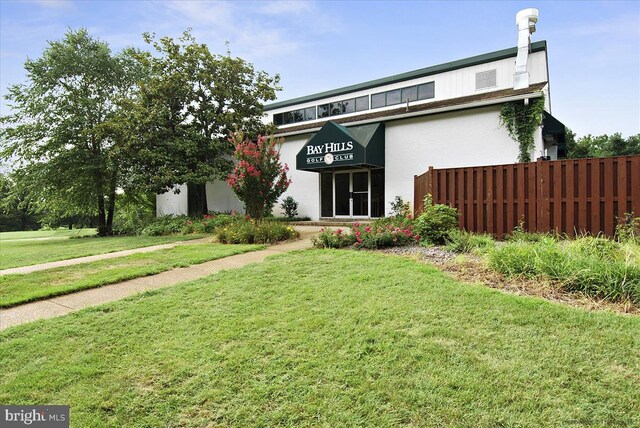 mid-century modern home with fence and a front yard