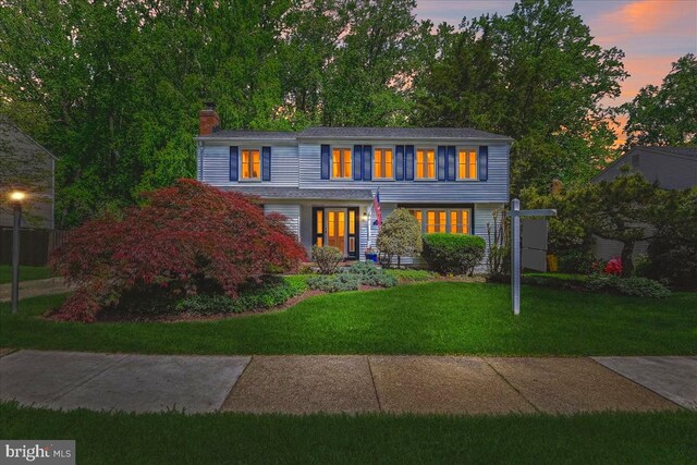 view of front of home with a chimney and a front yard