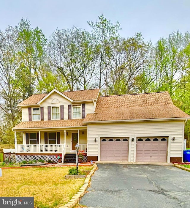 view of front facade with a porch, a garage, driveway, and a front lawn