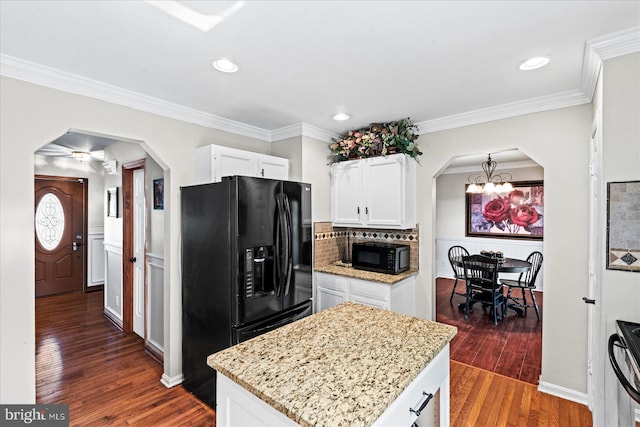 kitchen featuring crown molding, dark wood finished floors, arched walkways, white cabinets, and black appliances
