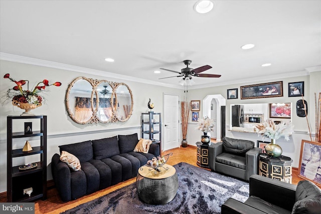 living room with recessed lighting, arched walkways, crown molding, and ceiling fan