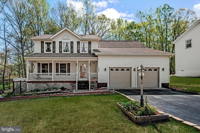 traditional home featuring aphalt driveway, a garage, covered porch, and a front yard