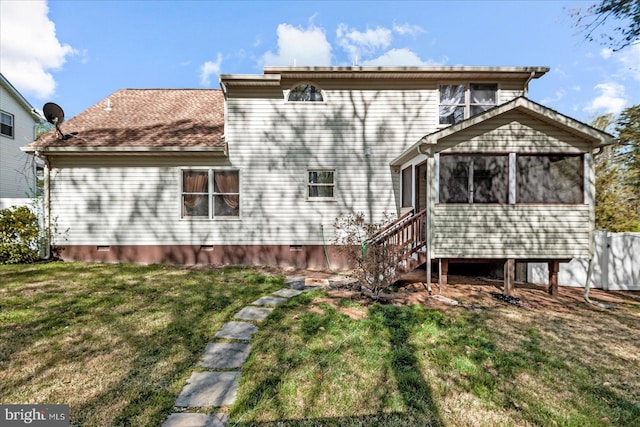 rear view of house featuring a sunroom, crawl space, and a lawn