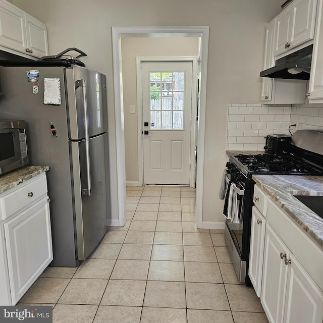 110 Harwich St, Browns Mills, NJ 08015 - kitchen with under cabinet range hood, stainless steel appliances, light tile patterned flooring, white cabinets, and baseboards