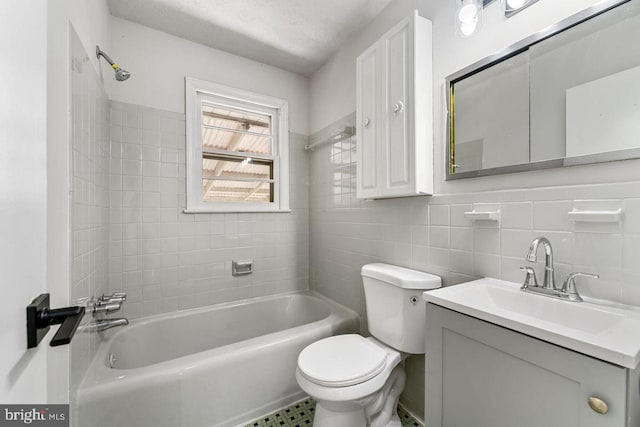 full bath with toilet, vanity, shower / bathtub combination, and tile walls