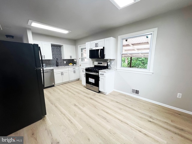 kitchen featuring light countertops, visible vents, appliances with stainless steel finishes, a sink, and backsplash