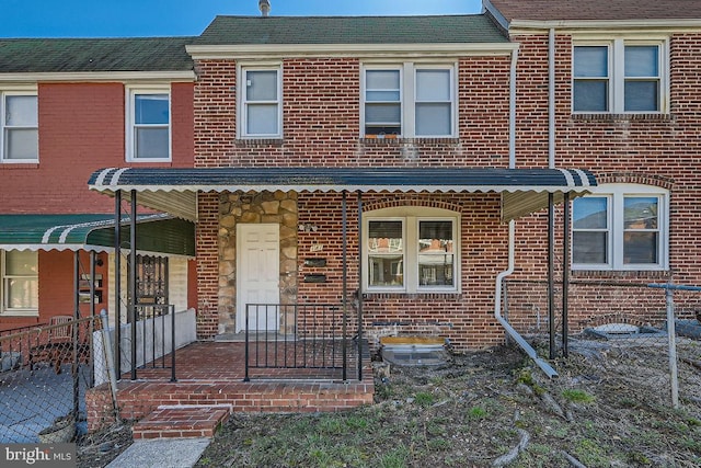 multi unit property featuring a porch and brick siding