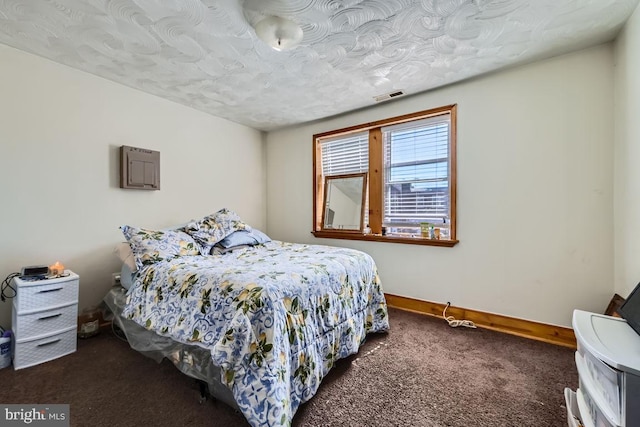 bedroom with baseboards, carpet floors, a textured ceiling, and visible vents