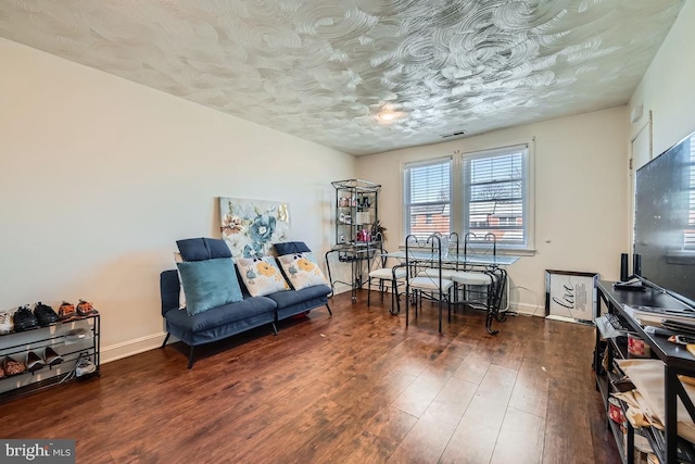 sitting room featuring visible vents, baseboards, and wood finished floors
