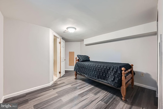 bedroom featuring baseboards and wood finished floors