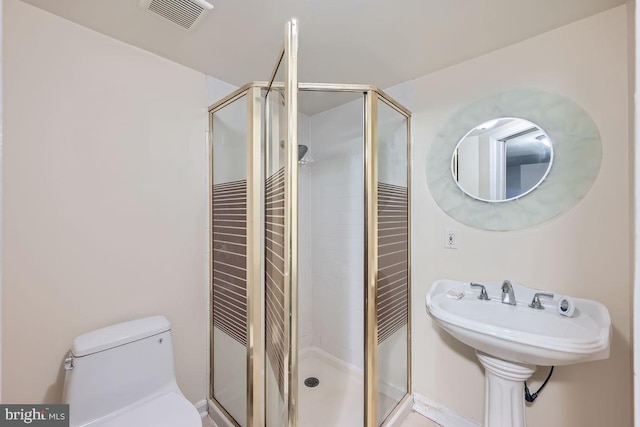 bathroom featuring a stall shower, visible vents, and toilet