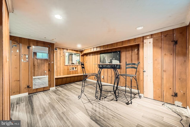 exercise area with wooden walls, baseboards, and wood finished floors