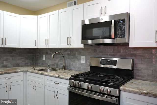 360 Haverford Ave, Wenonah, NJ 08090 - kitchen with visible vents, light stone countertops, white cabinetry, a sink, and stainless steel appliances