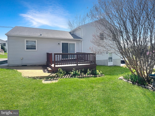 rear view of house featuring a wooden deck and a yard